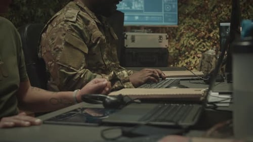 Two Diverse Colleagues Working at Military Control Center