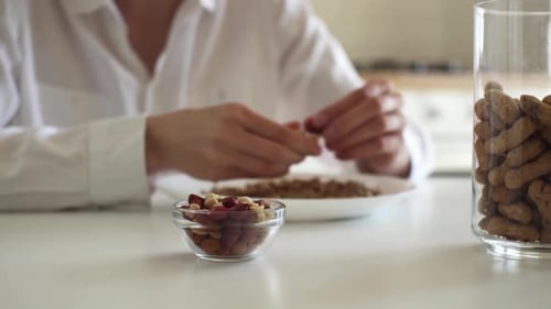 Shelling Peanuts at a White Table