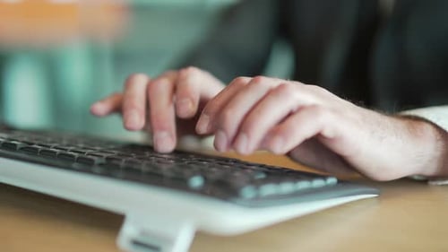 hands close up of business man in office typing on keyboard. male, employee, entrepreneur in a suit