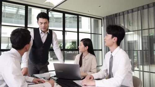 Professionals Meet Around Table in Modern Office