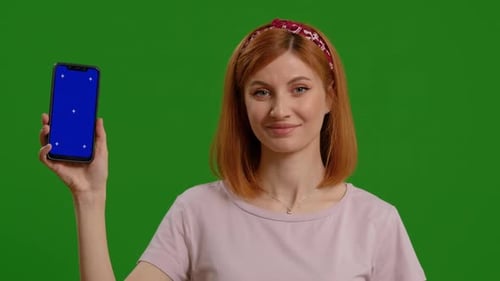 Woman Holds Smartphone with Blue Screen on Green Screen