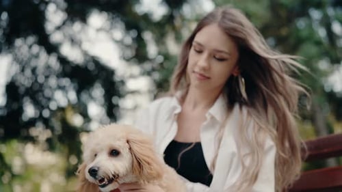 Young Woman with Her Adorable Fluffy Dog in the Park