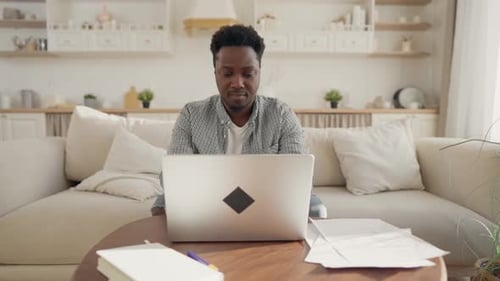 Man Using Laptop Working from Home on Couch