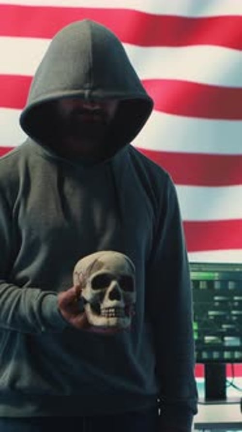 Vertical Video American Man in a Dark Hood Making Death Threats with Human Skull Concept