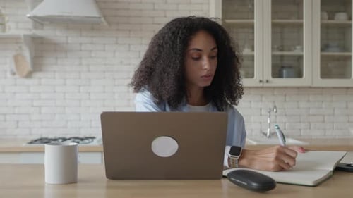 Woman Working at Laptop in Bright Kitchen