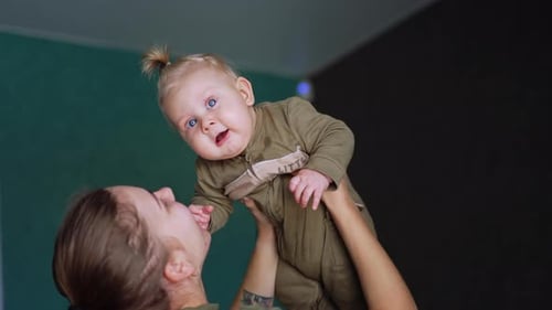 Woman Holds Baby Up Laughter Affection