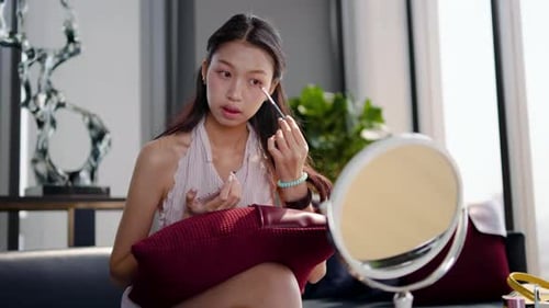 Young Woman Applies Makeup with Brush at Home