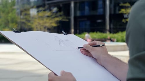 Unrecognizable person sketching a building exterior . Shot with RED helium camera in 8K
