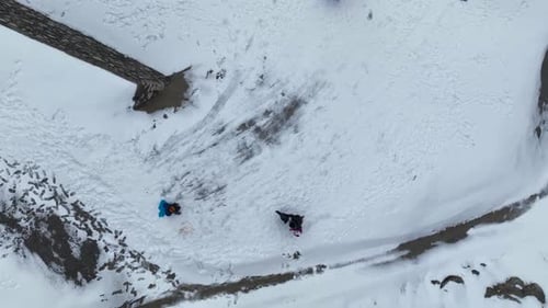 A Child Rides Down a Snowy Hill