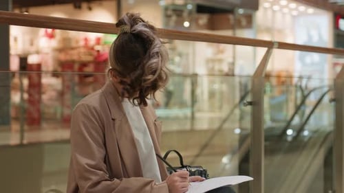 Teenage Girl Drawing While Sitting in Shopping Mall
