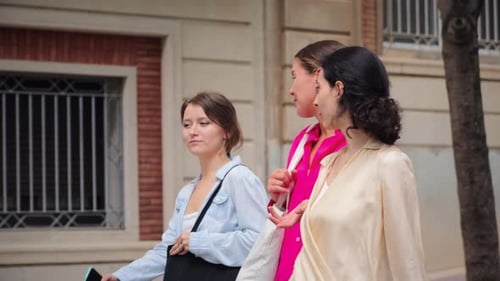 Women Friends Strolling Along City Street Chatting