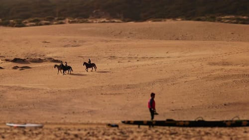 Reiter am Strand Pferde laufen langsam Windsurfer mit Paddel in der Nähe des Meeres