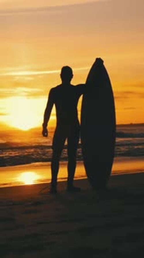 Silhouette of a Surfer on Beach at Sunset