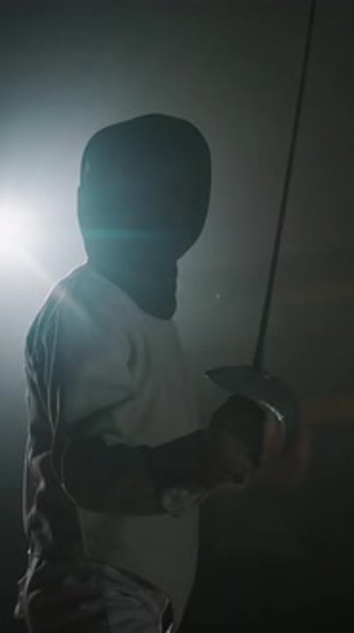 Vertical of Male Foil Fencer Putting on Epee Mask and Starting Duel