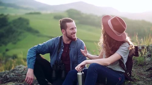 Smiling Couple Relaxing Together on Mountain Top