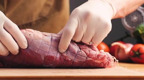 Hands Preparing Meat on a Cutting Board