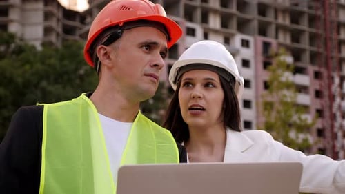 A Builder and an Architect with a Laptop are Standing at a Construction Site