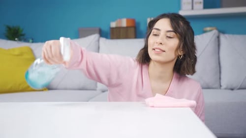 Woman Cleans Table with Spray Cleaner at Home