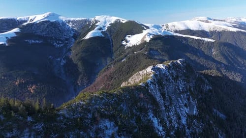 Aerial View of Snow-Capped Mountains with Clear Blue Sky in Winter Serenity