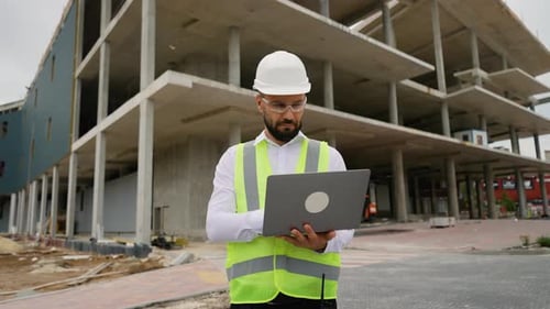 Civil Engineer Using Laptop at Construction Site