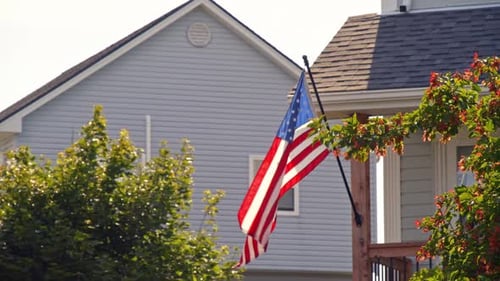American Flag waving in front of suburban home