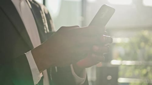 Close Up Male Hands Typing on Smartphone Device in Sun Sunshine Cropped View Unrecognizable African