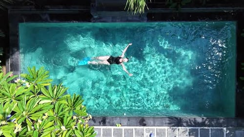A Top View of a Swimmer in a Clear Blue Swimming Pool with Flippers Enjoying a Leisurely in Bali