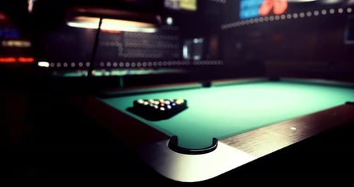 Pool Table Set Up in a Dimly Lit Bar with Vibrant Background Lights