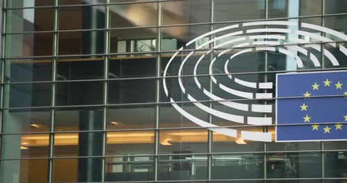 logo of europe with yellow stars on window of the the European parliament building in Brussels.