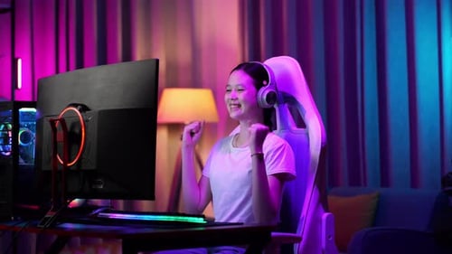 Teen Girl Celebrates Gaming Win at Computer