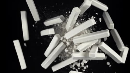 School Chalk Flies Up and Falls Down on a Black Background Filmed on a Highspeed Camera at 1000 Fps