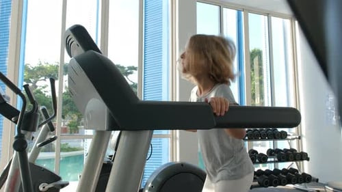Little Girl Jogging on Treadmill During Workout