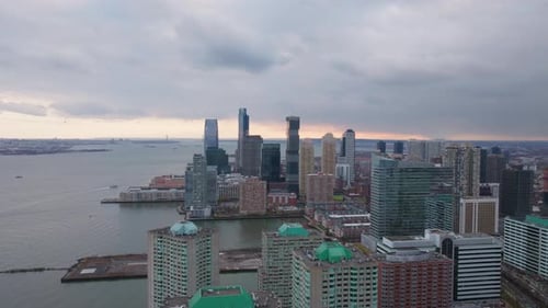 Jersey City Skyline Glimmering at Sunset Clouds Hovering Over Hudson River Urban Landscape in Soft