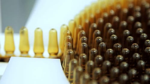 Pharmaceutical ampoules on automated manufacturing line at pharmacy factory