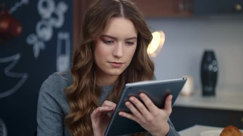 Woman using tablet in modern kitchen