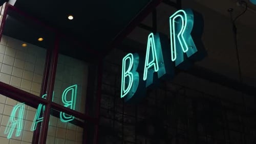 A Brightly Glowing Neon BAR Sign Illuminated at Night Evoking a Lively Urban Atmosphere in the City