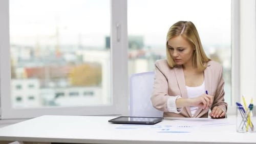 Woman Works with Tablet at Desk in Office