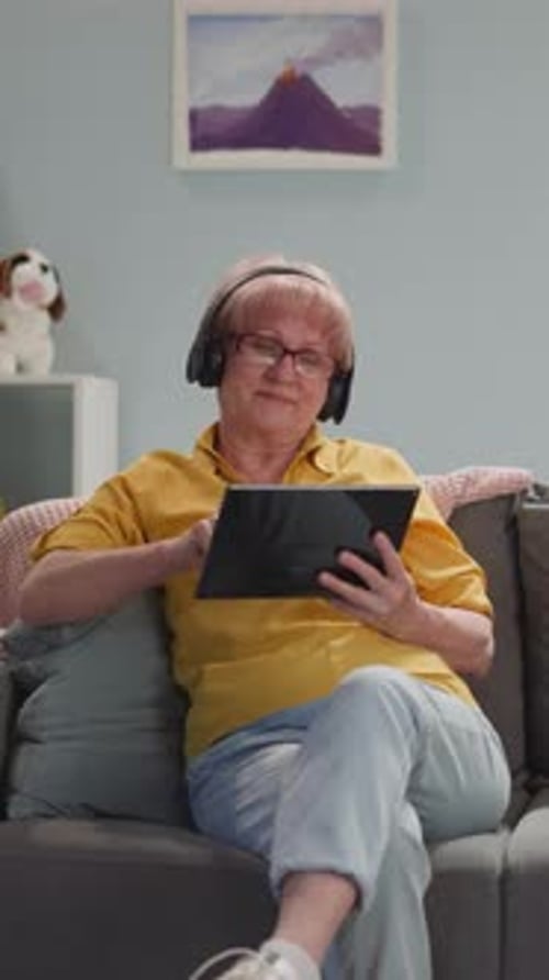Senior Woman Relaxing on Couch Using Tablet