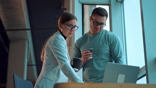 Business Colleagues Discussing Work on Laptop in Office