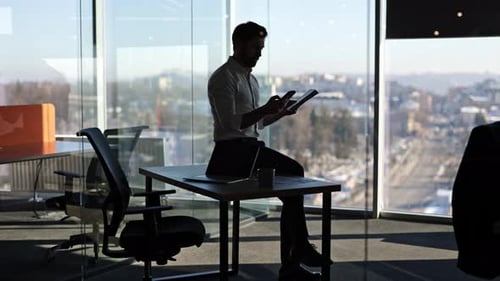 Businessman Using Tablet in Modern Office with City View