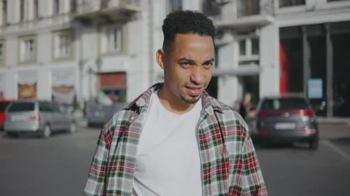 Portrait of a Young African American Man on the Street A Young Guy on the Street and Looks at the