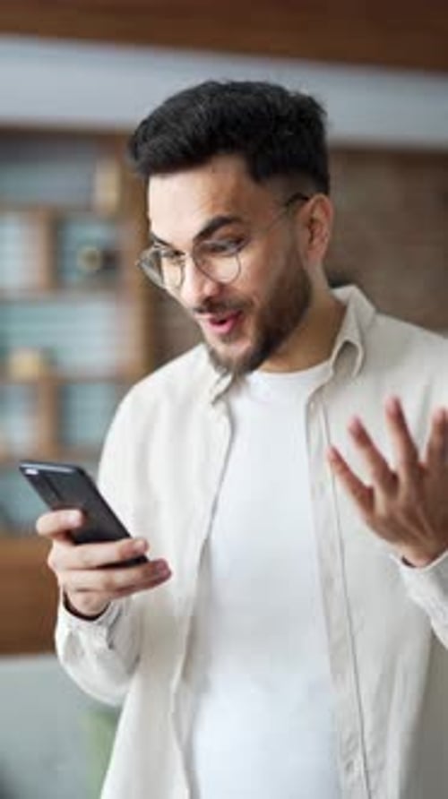 Excited Man Reacts to Phone in Vertical Video