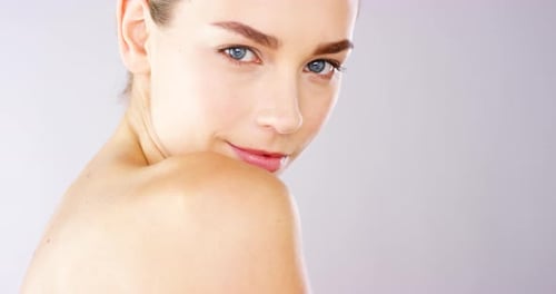 4k video footage of an alluring beautiful woman posing against a studio background