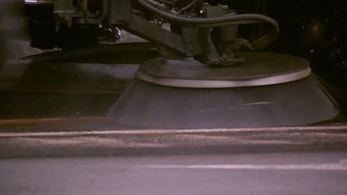 STREET SWEEPER CLEANING UP SIDE OF ROAD