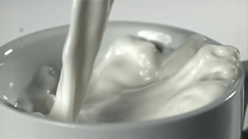 Fresh Milk is Poured Into a Cup Filmed on a Highspeed Camera at 1000 Fps