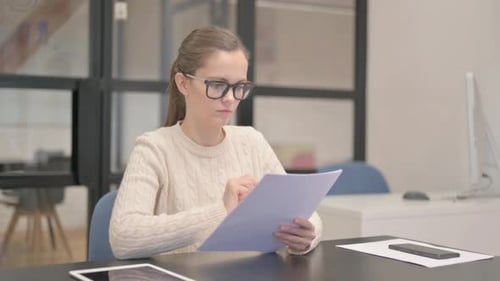 Young Woman Reading Documents at Work