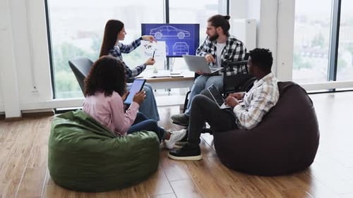 Group of Diverse Young Professionals Brainstorming Car Design in Workspace