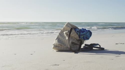 Video einer Tasche mit Strandausrüstung, die am Strand auf Sand liegt