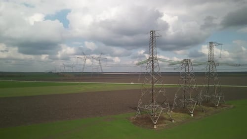 Aerial View of Power Lines Over Green Agricultural Field