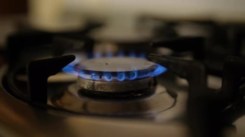 Closeup of Gas Stove Burner with Vibrant Blue Flame Showcasing Intense Heat and Energy Required for